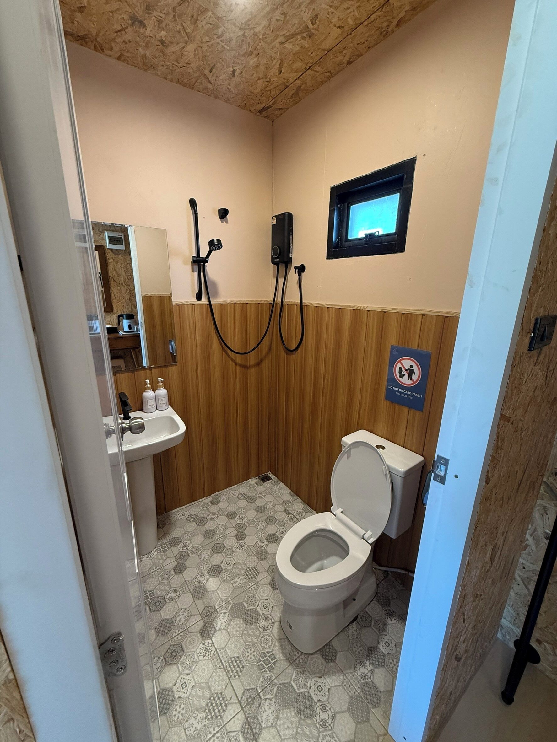 Un bany petit amb vàter, un lavabo i una dutxa.
