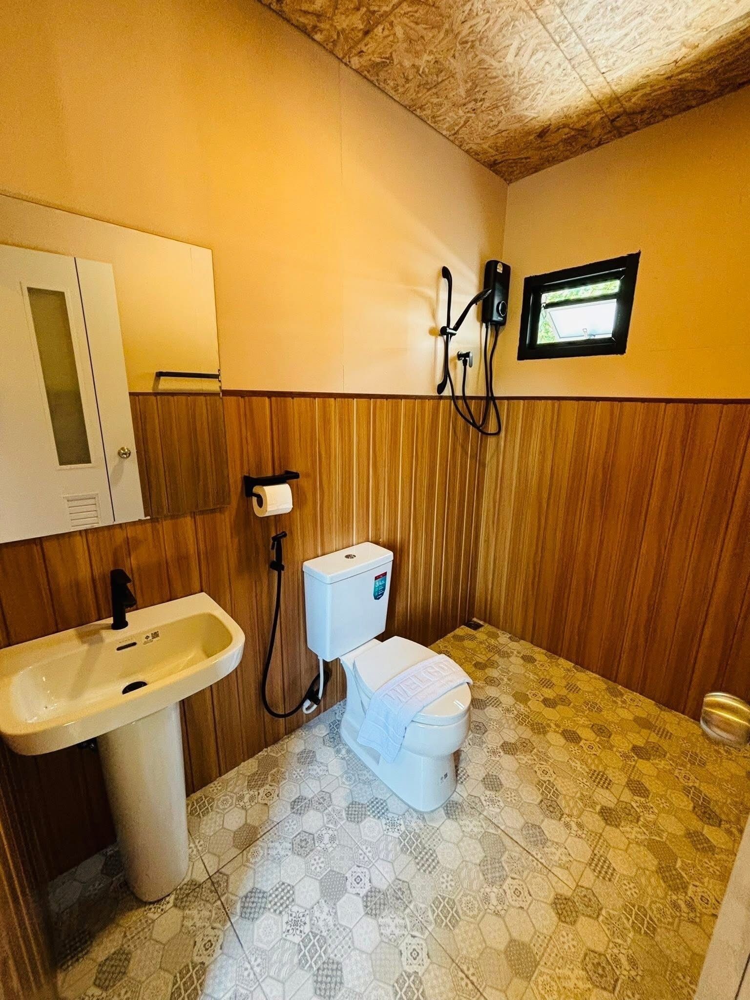 A bathroom with a toilet, sink, and shower.