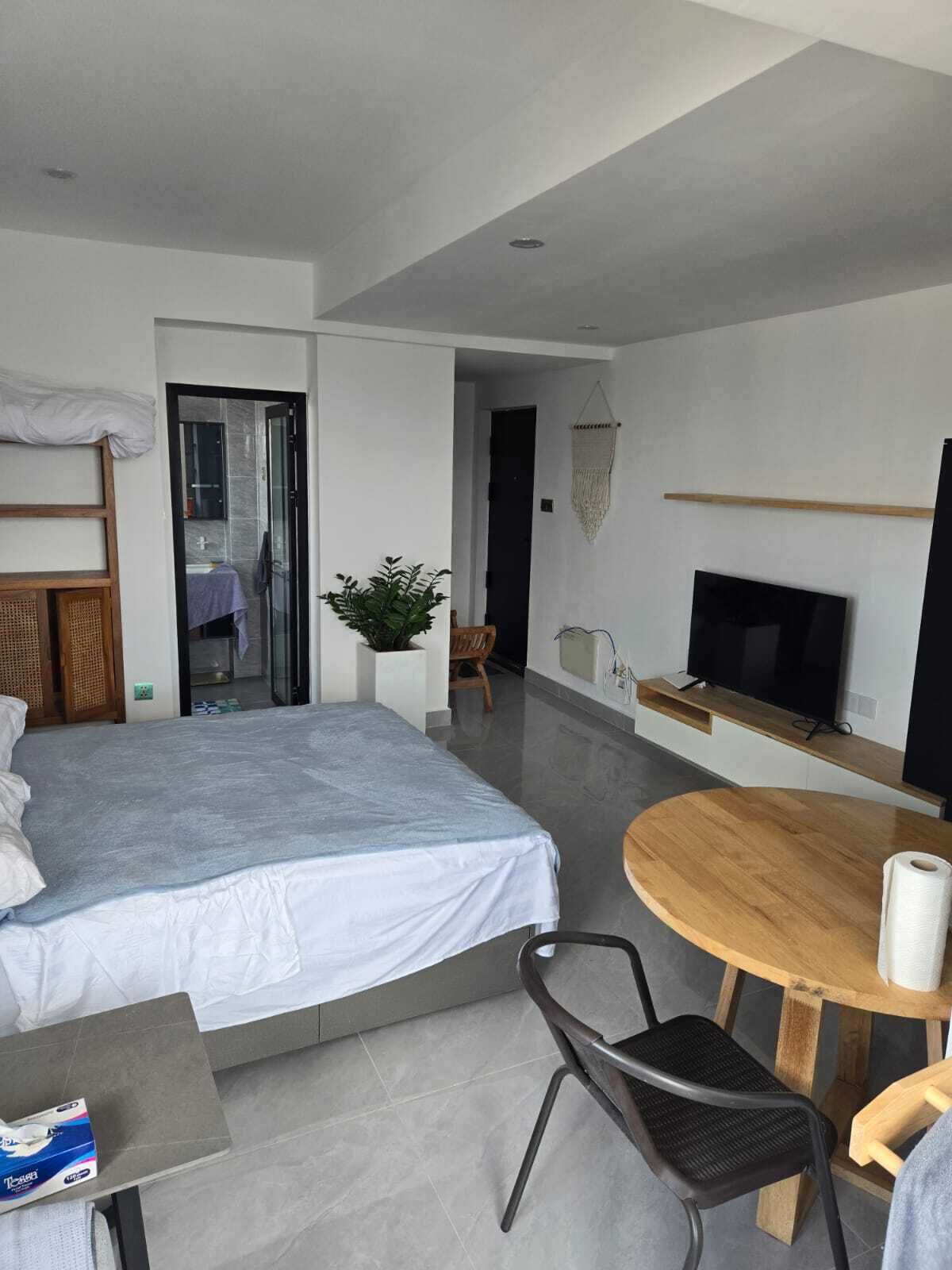 Une chambre d’hôtel moderne équipée d’un lit, d’une télévision, d’une table à manger et d’un petit coin salon.