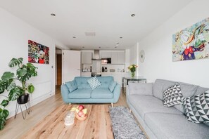 Un salon moderne avec un canapé, une table basse et des œuvres d’art accrochées aux murs.