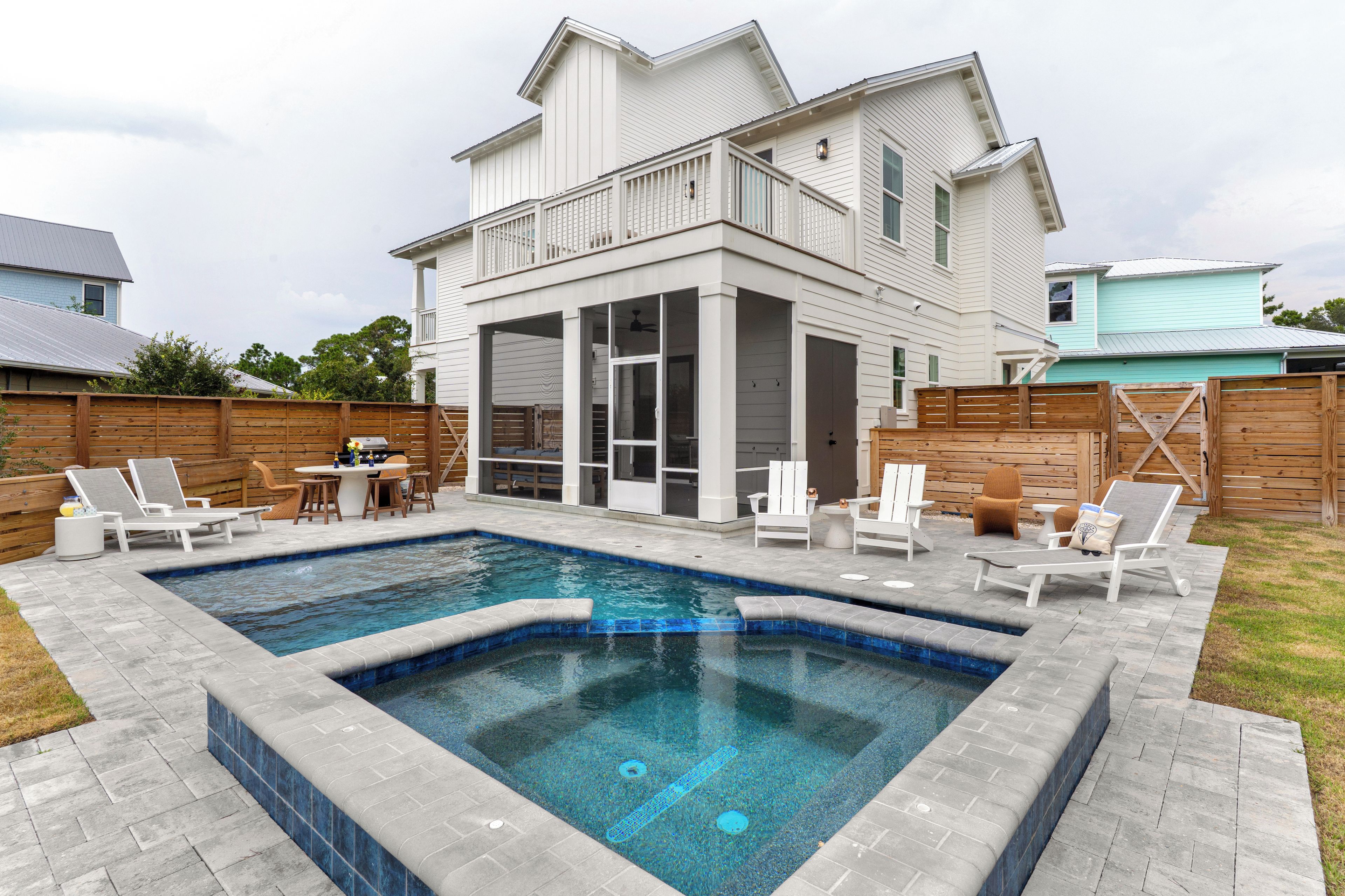 Modern backyard oasis with a sleek pool, raised spa, and plenty of loungers for sun‑soaked 30A days.
