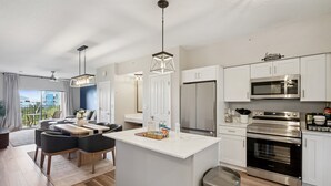 Een moderne keuken met witte kasten, roestvrijstalen apparatuur en een centraal eiland.