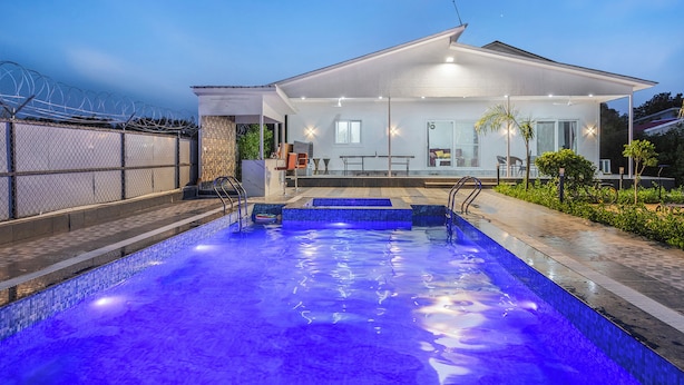 A modern house with a swimming pool, a covered patio, and a fenced yard.