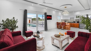 A modern living room with red sofas, a coffee table, and a TV displaying 'NETFLIX'.