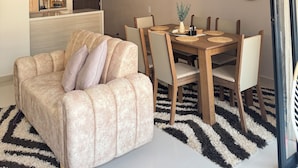 Ein moderner Essbereich mit rundem Tisch, Stühlen und einer Couch.