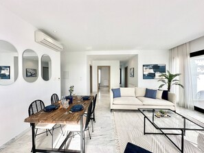 Ein modernes Wohnzimmer mit Essbereich, einer Couch und einem Couchtisch.