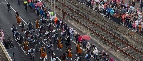 Una calle llena de gente con una banda tocando.