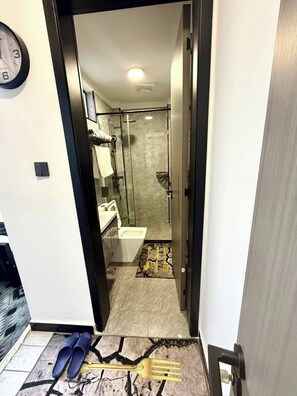 A hotel bathroom with a shower, toilet, and sink. - Executive Two bedroom Neptune Lavington (Nairobi)