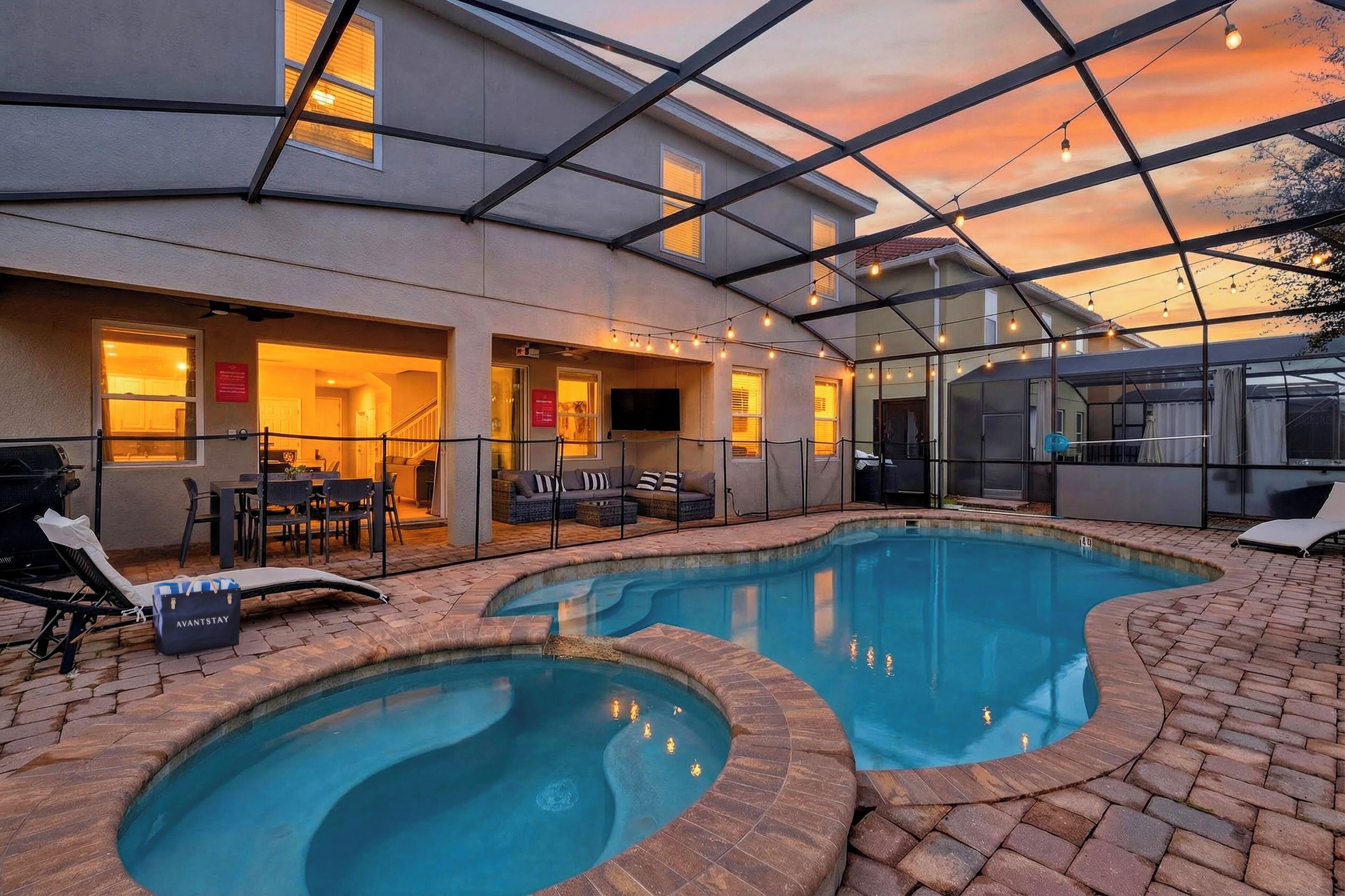 Golden-hour perfection in your screened lanai—heated pool + bubbling spa, string lights overhead, and plenty of space to lounge after the parks.
