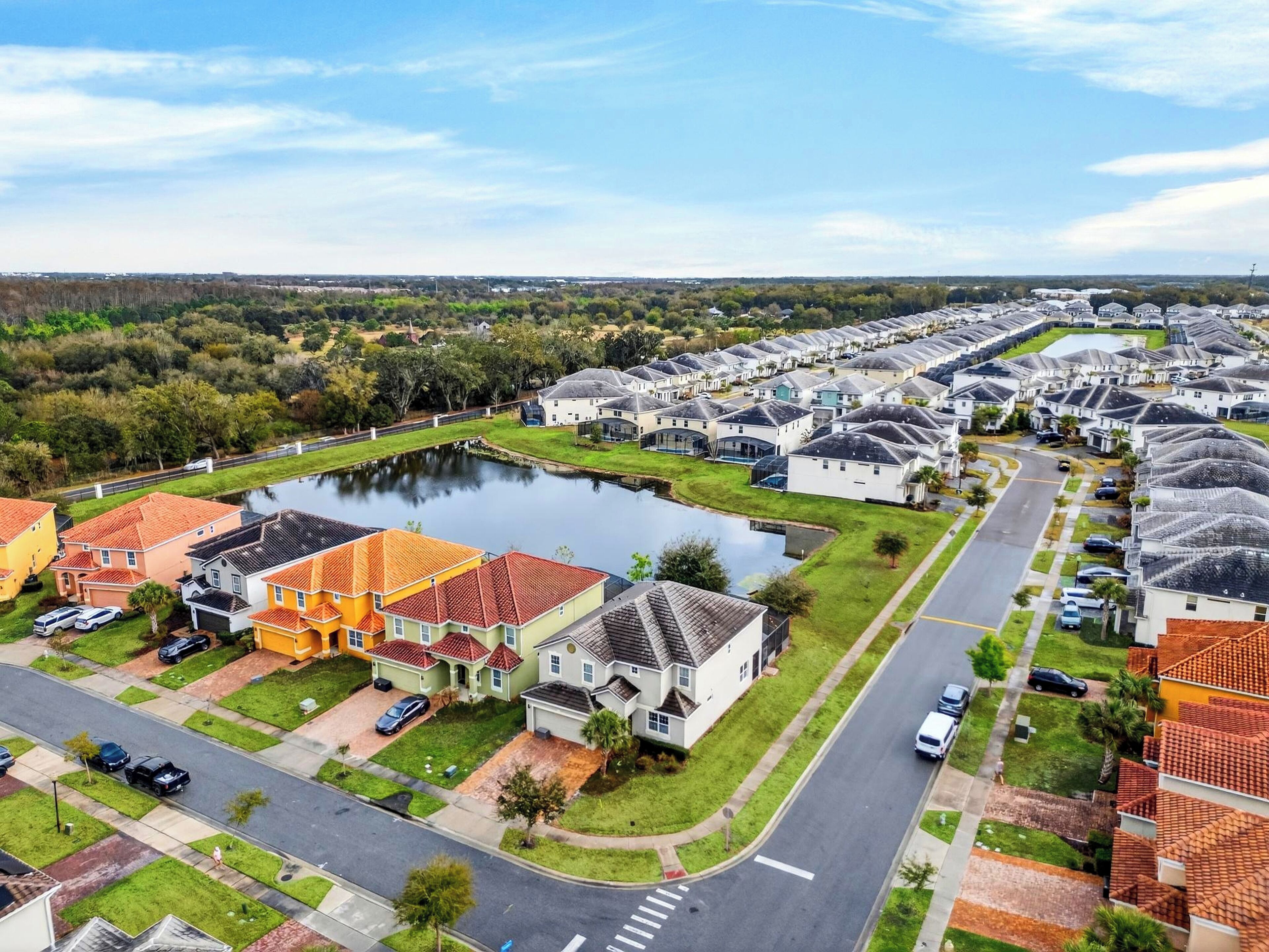 A residential area with houses, a road, and a body of water.