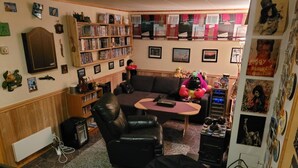Una sala de estar con un sofá, una mesa de centro, una estantería y un televisor.