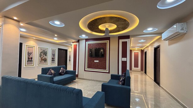 A modern lobby with blue sofas, a decorative wall panel, and recessed ceiling lighting. - Hotel Shri Ram Legacy (Jodhpur)