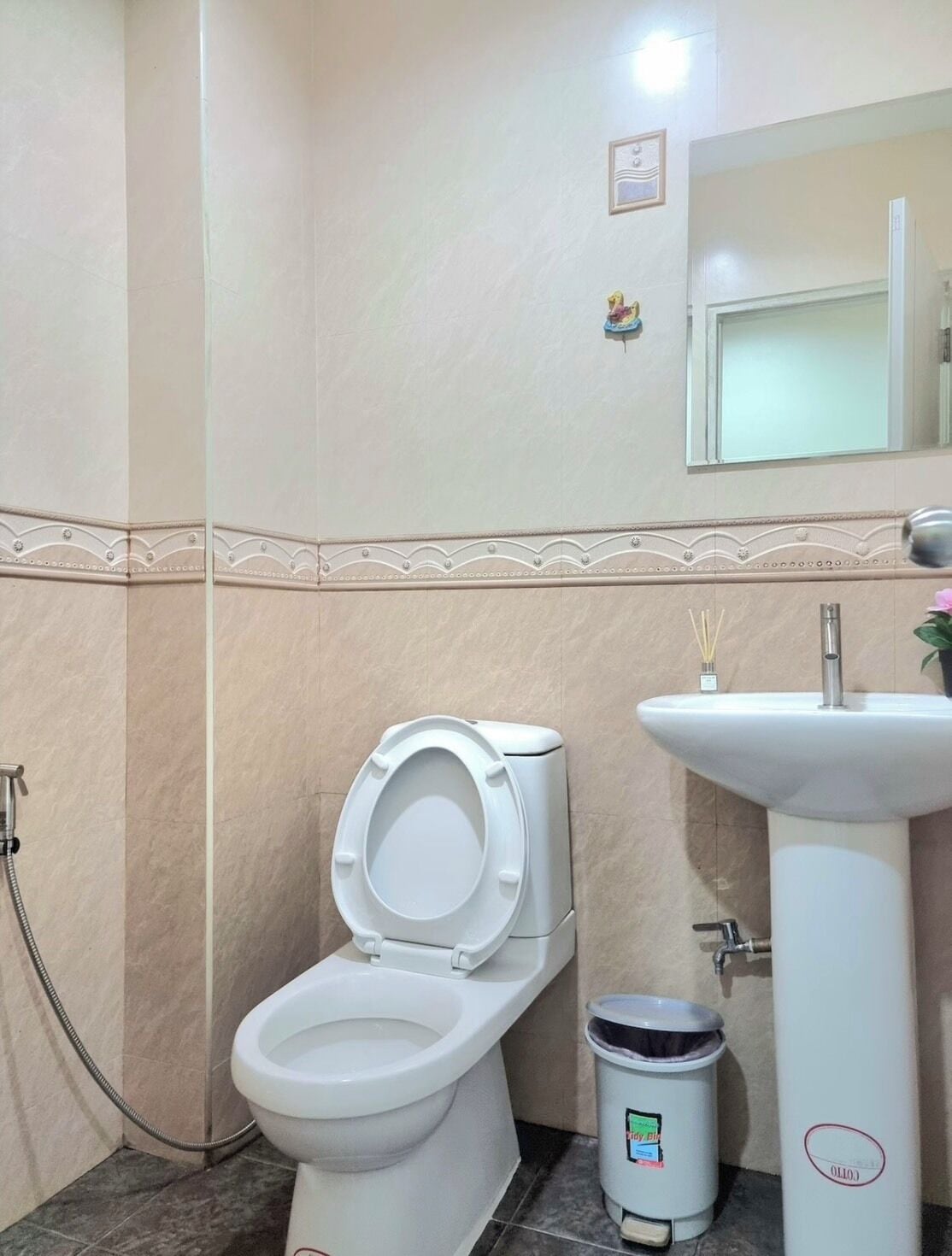 Ein Badezimmer mit Toilette, Waschbecken und Mülleimer.