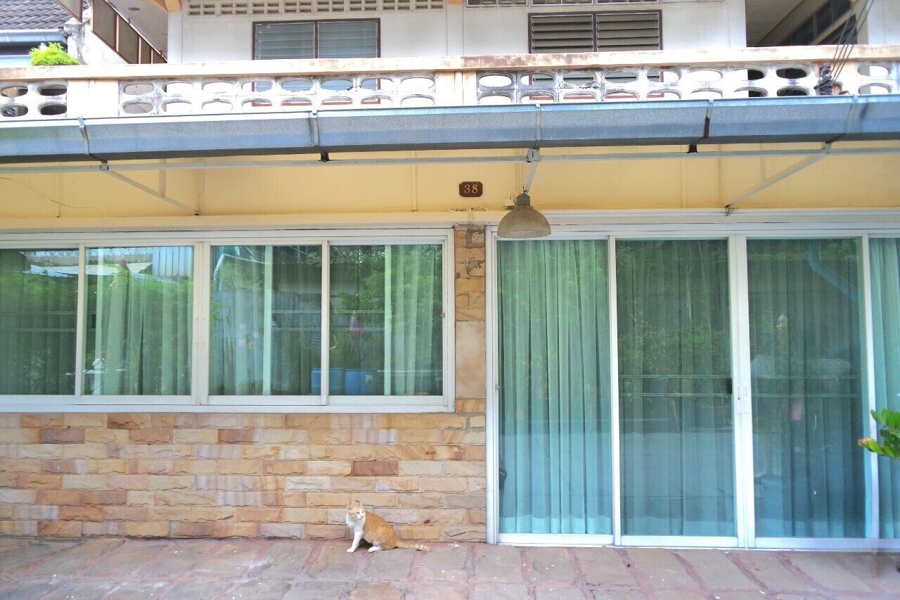 A building with a stone facade, a balcony with a railing, and a sliding glass door.
