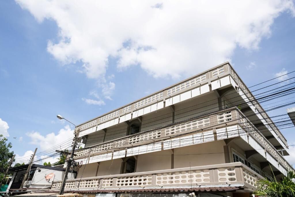A multi-story building with balconies, power lines, and a clear sky.