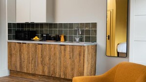 A compact kitchen with a wooden countertop, a microwave, a coffee maker, and a sink. - Settle Southampton (Southampton)