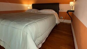 Una cama individual en una habitación con paredes a rayas y suelo de madera.