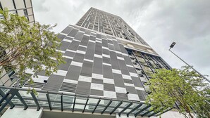 A modern high-rise building with a grid-like facade, large windows, and a glass balcony. - Chambers Residence by Airhost (Kuala Lumpur)