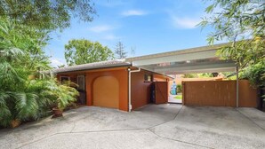 Uma garagem com abrigo coberto, porta fechada e calçada de concreto.