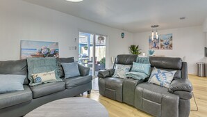 A modern living room with two leather sofas, a round coffee table, and a dining area visible through a glass door. - 1/2 Mi to Sylvan Beach Park! Chic Townhome w/ Yard (La Porte)