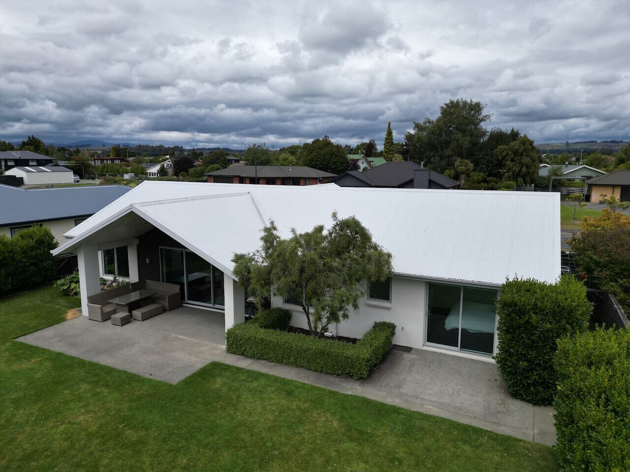 A modern house with a sloped roof, a covered porch, and a well-maintained lawn.