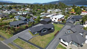 Un quartier résidentiel composé de maisons, dont certaines sont dotées de garages attenants, et offrant une vue dégagée sur un lac et des montagnes en arrière-plan.