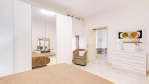 Quarto com cama, guarda-roupa, cadeira, cômoda e espelho.