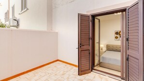 Quarto com cama, mesa de cabeceira e ar-condicionado fixado na parede.