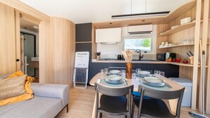 A compact living space with a kitchenette, dining area, and a sofa.