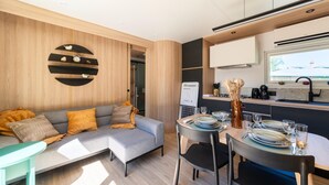 A modern kitchen with a dining area, a sofa, and a small table.