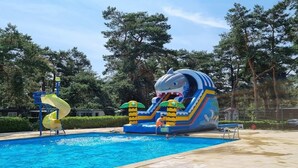 A swimming pool with a slide and inflatable shark play area. - Mobile home Keiheuvel (6p) (Balen)