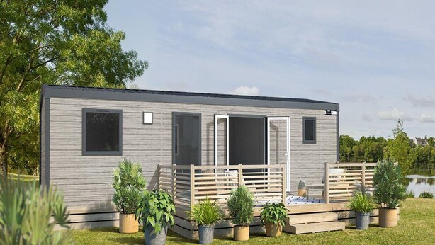 A modern mobile home with a deck, surrounded by potted plants. - Mobile home Keiheuvel (6p) (Balen)