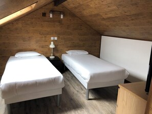A small, cozy room with two single beds, a nightstand with a lamp, and a wooden ceiling. - Beautiful duplex apartment for 5 people, 5 minutes from the IGR Metro Station 14, 10 minutes from Paris (Villejuif)