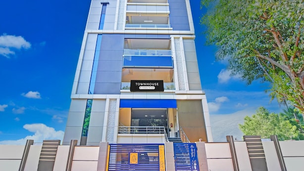 A multi-story building with a sign reading 'Townhouse & Company Service.' - Blissful Stays at Dwarakanagar Near Gurudwara (Visakhapatnam)