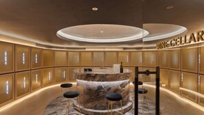 A luxurious wine cellar with marble countertops, gold accents, and a circular bar area.
