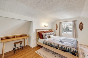 Ein Schlafzimmer mit einem Bett, einem Schreibtisch und einem Fenster.
