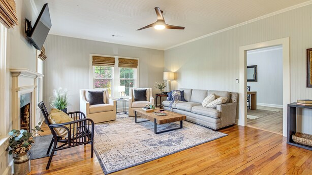 A living room with a fireplace, a ceiling fan, a sofa, a coffee table, and a rug. - 9 Mi to Georgia Southern University: Family Escape (Brooklet)