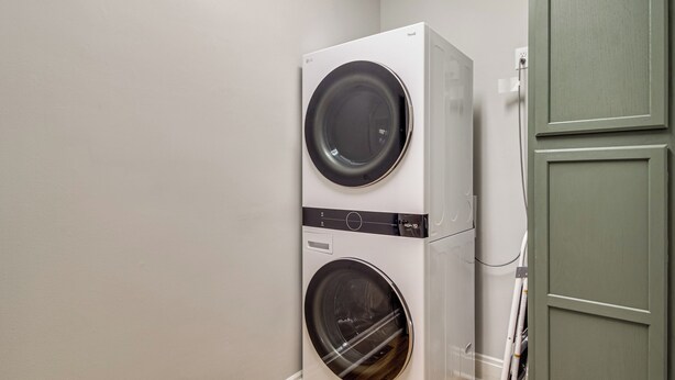 A stacked washer and dryer unit in a room with light-colored walls and a green door. - 9 Mi to Georgia Southern University: Family Escape (Brooklet)