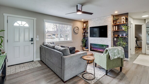 Ein Wohnzimmer mit einer Couch, einem kleinen runden Tisch, einem Fernseher und einem Kamin.