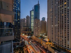 A cityscape with high-rise buildings, a busy street, and a view from a high vantage point. - Beach Lux New 2BD | Marina view | CEG Group (Dubai)
