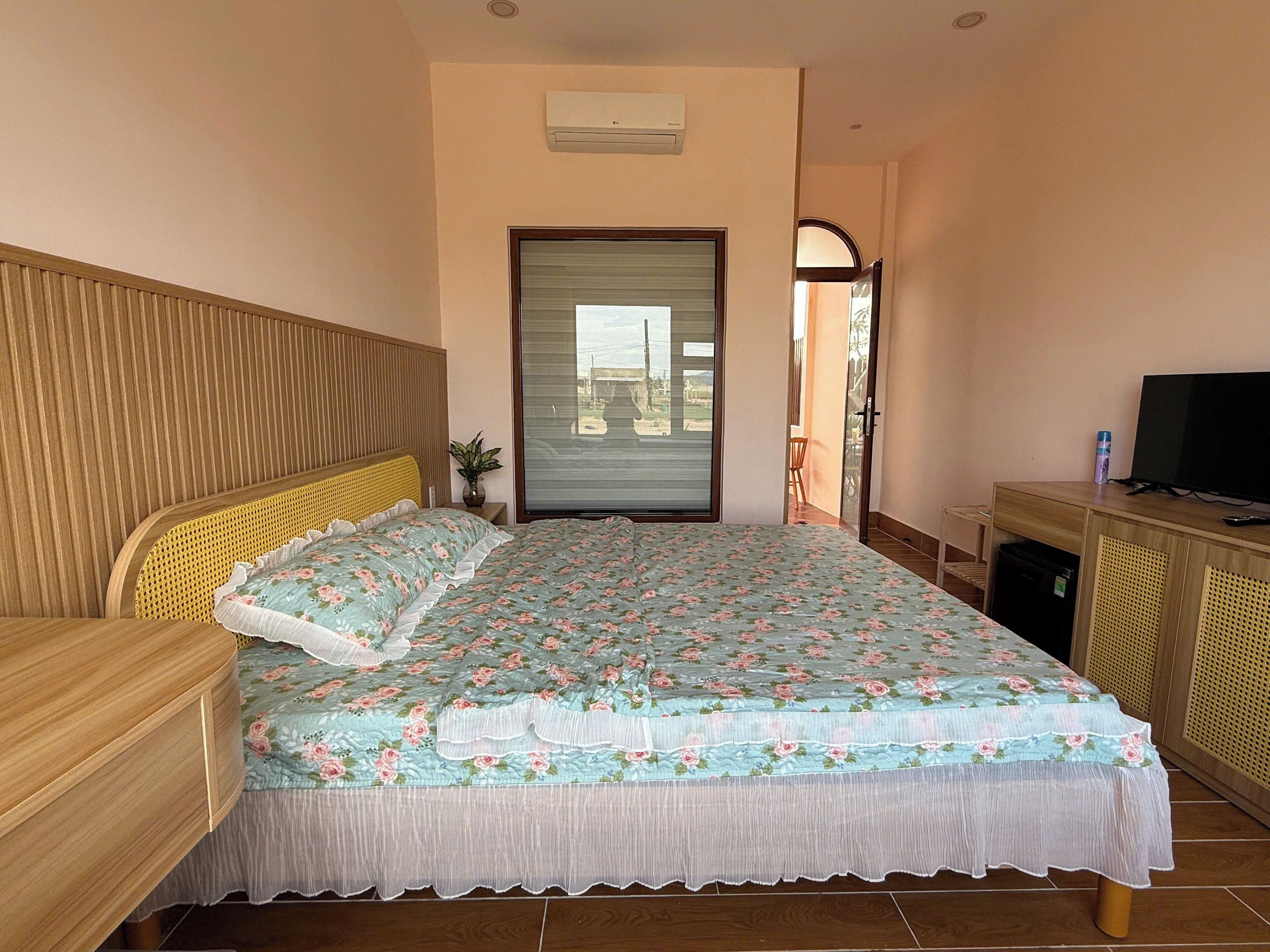 Une chambre à coucher avec un lit, une télévision, un bureau et une fenêtre.