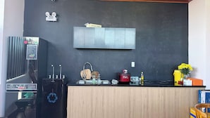 A modern kitchen with a black countertop, wooden cabinets, a built-in microwave, and a stainless steel sink.