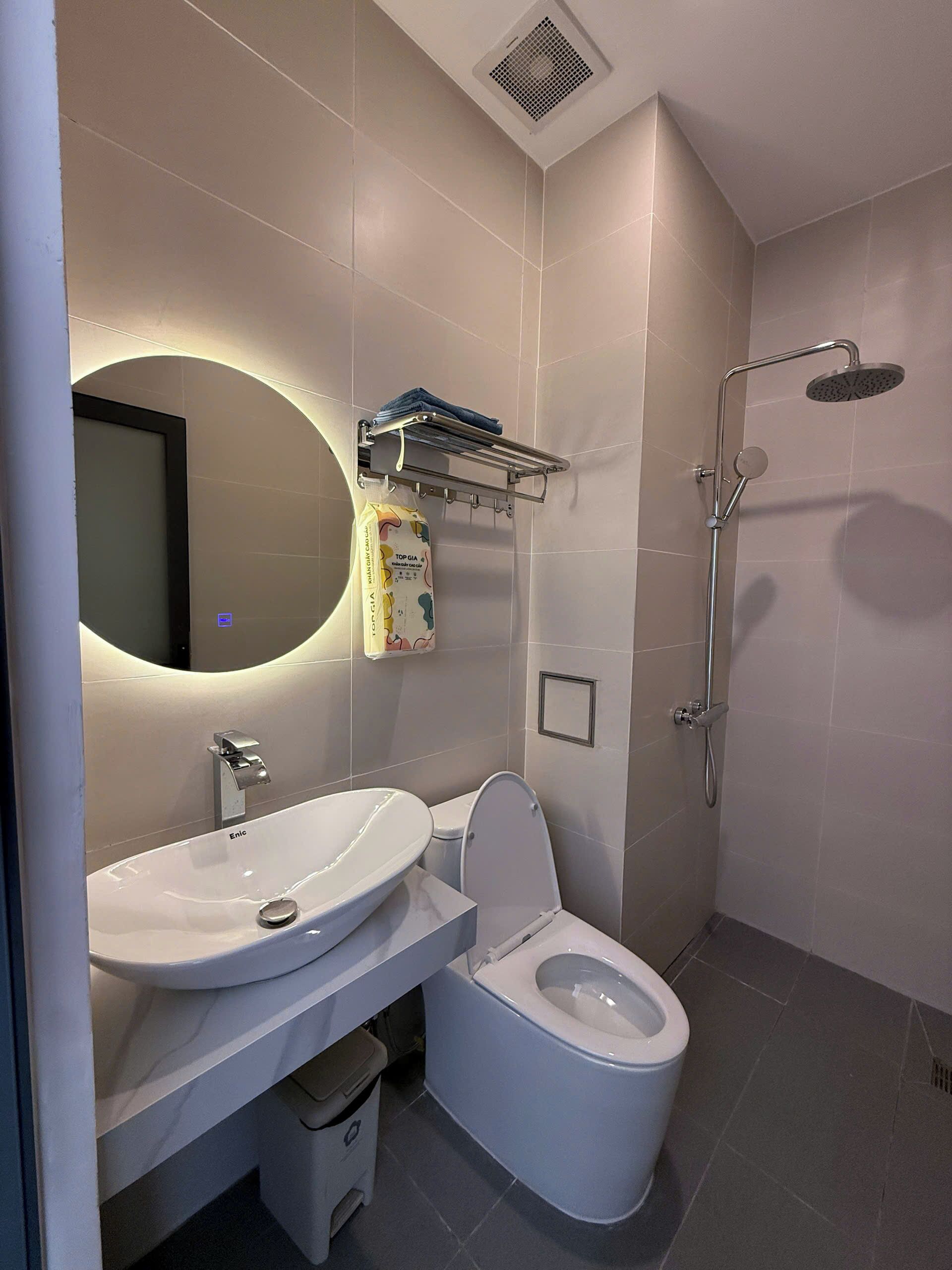 Een moderne badkamer met een wastafel, toilet en douche.