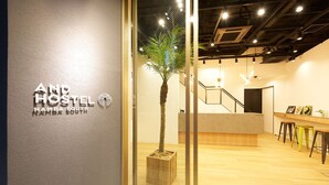 A reception area with a modern design, including a reception desk, a staircase, and a potted plant.