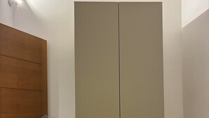 A room with a wooden door, a beige wardrobe, and light-colored wooden flooring. - Domus Gazzara, cozy and comfortable vacation home in the heart of the historic center (Napoli)