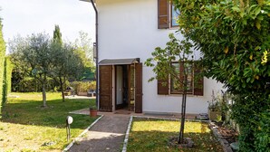 Ein modernes Haus mit befestigtem Eingangsbereich, einem kleinen Garten und einem Briefkasten.