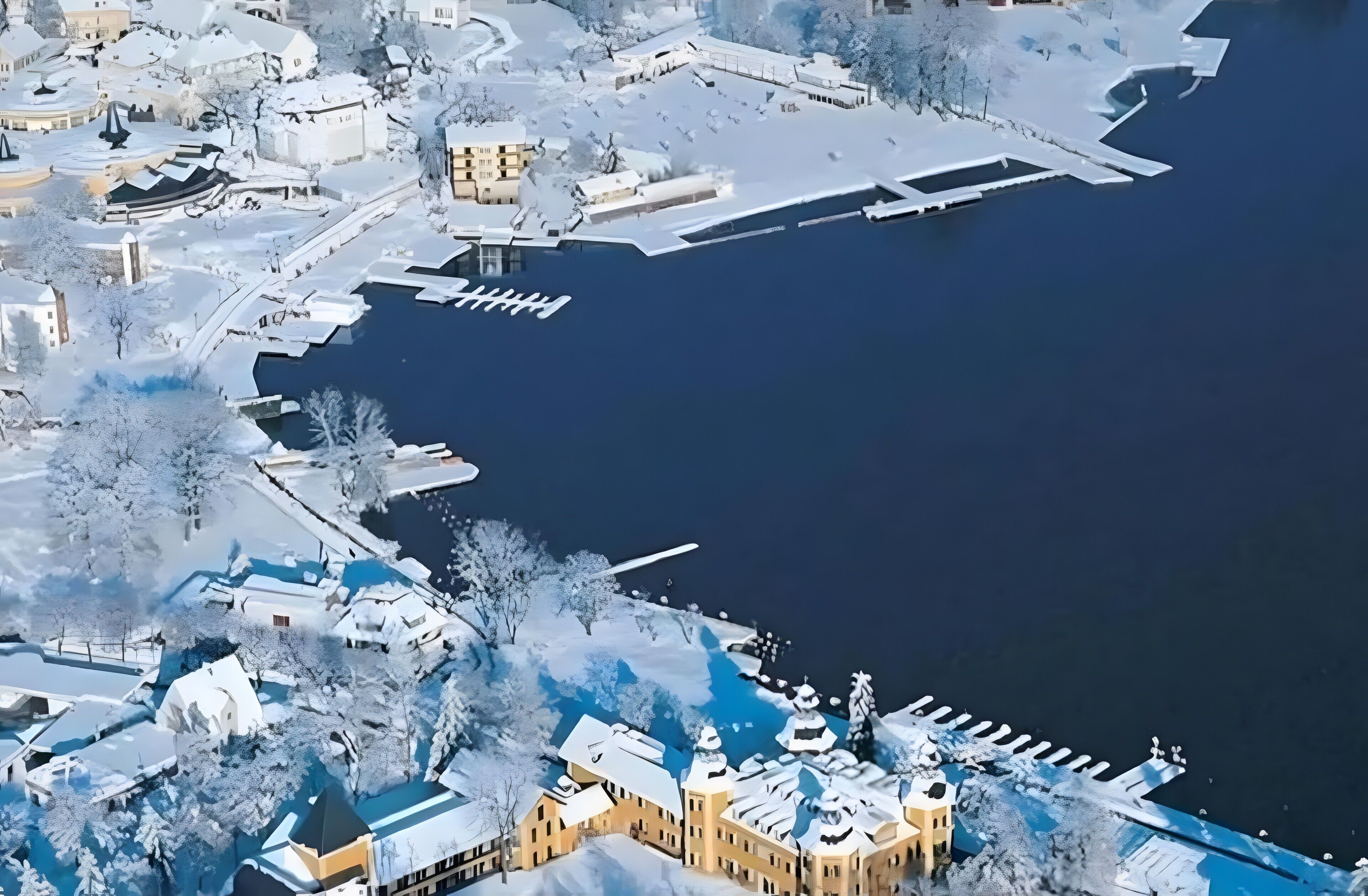 En vinterscen med snötäckta byggnader och en hamnfront.