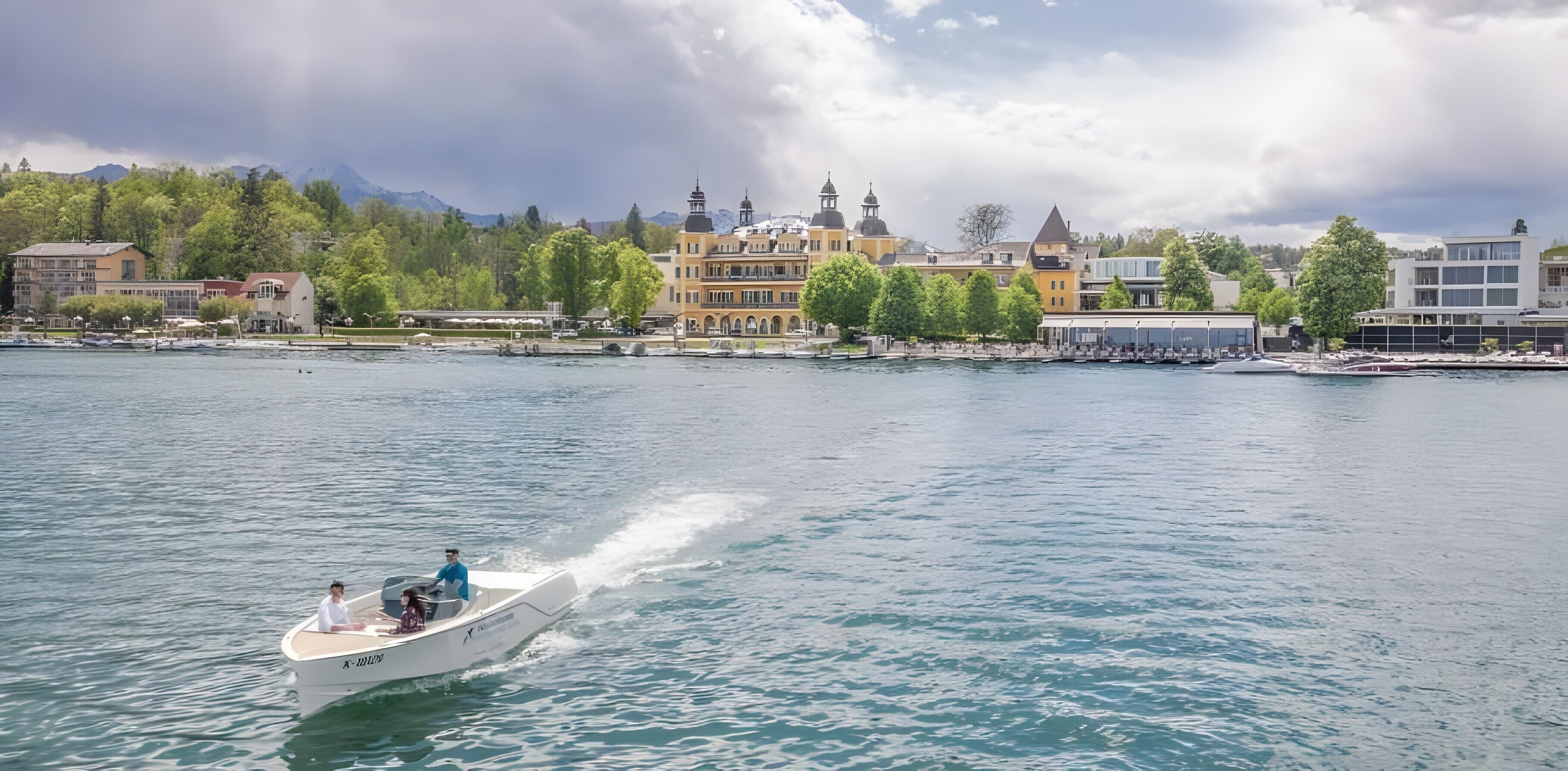 A boat on a calm lake with buildings in the background.