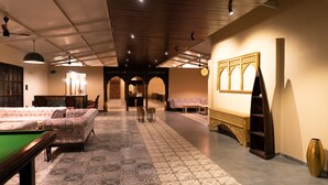 Une salle de billard équipée d’une table de billard, de canapés et d’un mur décoratif.