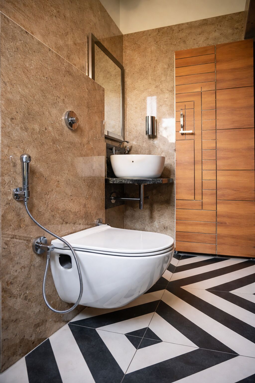 A bathroom with a freestanding toilet, a wall-mounted sink, and a wooden door.